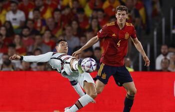 El portugués Cristiano Ronaldo (i) lucha con el español Pau Torres por la posesión del balón, durante el partido que disputaron ayer en Sevilla.