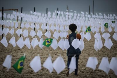 Una voluntaria ayuda a colgar pañuelos blancos durante un homenaje a las miles de víctimas mortales de la covid-19 en Brasil.
