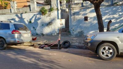 Sumidero fue señalado por vecinos con ruedas, cintas y cartel de tránsito viejo.