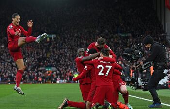 El neerlandés Virgil van Dijk ensaya una patada en el aire para sumarse al festejo de sus compañeros de Liverpool, tras el primer gol anotado por su compatriota Cody Gakpo.