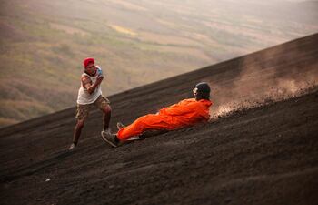 Un turista se desliza por las laderas del volcán Cerro Negro, el más joven de Centroamérica (167 años) y uno de los más activos del país, en León, Nicaragua. El abordaje del volcán en el Cerro Negro atrae cientos de visitantes que quieren vivir experiencias extremas.