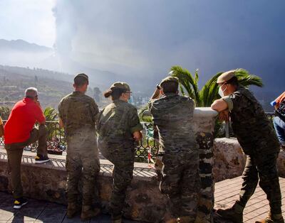 Efectivos militares observan las evoluciones del volcán desde la plaza de la iglesia de Tajuya, tras el desmoramiento parcial del cono la pasada noche. La nueva colada de lava está generando una tremenda destrucción a su paso y dificultando el movimiento de los científicos en la zona, ha advertido este sábado el Instituto Volcanológico de Canarias (Involcan).