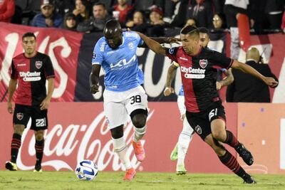 El paraguayo Víctor Gustavo Velázquez (d), defensor de Newell's, disputa el balón con el colombiano José Sinisterra, delantero del Blooming.