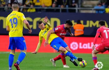 El paraguayo Omar Alderete, del Getafe, desplaza con el cuerpo a Rubén Alcaraz, del Cádiz, para hacerse con el balón durante el partido disputado ayer. (Foto gentileza).