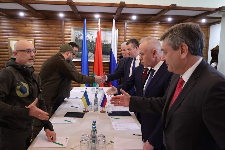 Foto de la agencia oficial bielorrusa, Belta, del saludo de las delegaciones de Ucrania y Rusia, hoy durante la segunda ronda de diálogos.
