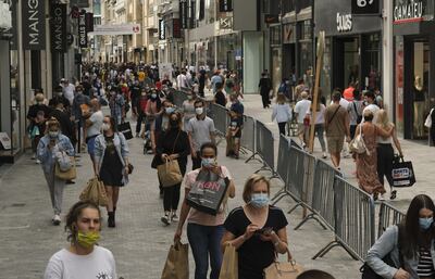 Compradores con máscarillas pasean por la principal calle comercial de Bruselas, Bélgica.