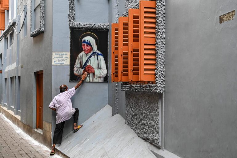 Un devoto toca una fotografía de la Madre Teresa buscando su bendición, en ocasión del 111 aniversario de su nacimiento en agosto pasado.