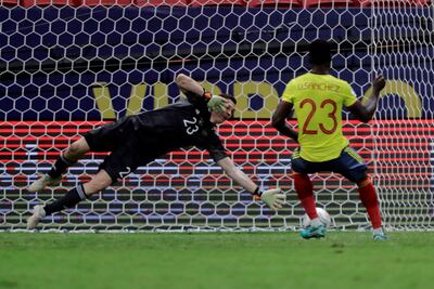 El arquero argentino Emiliano Martínez se tira a su izquierda y tapa el penal rematado por el colombiano Davinson Sánchez.