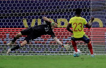 El arquero argentino Emiliano Martínez se tira a su izquierda y tapa el penal rematado por el colombiano Davinson Sánchez.