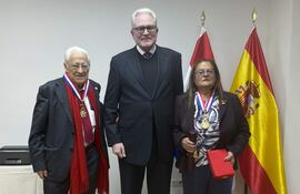 El presidente de la asociación Mensajeros de la Paz, el padre Ángel García (i) y la profesora María del Carmen Hidalgo, tras recibir de manos del embajador de Paraguay en España, Ricardo Scavone (c), la condecoración de la Orden nacional al Mérito "Don José Falcón", durante un acto celebrado hoy martes en Madrid.