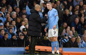 Pep Guardiola, entrenador del Manchester City, dando algunas indicaciones al noruego Erling Haaland, quien está en duda para el juego de hoy ante Liverpool.