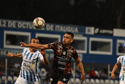 Alex Garcete, zaguero del 12 de Octubre, disputa el balón con el delantero de Guaireña, Nildo Viera, en juego sin goles.