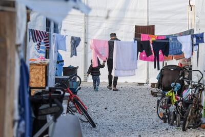 Un hombre y una niña caminan por el Centro de Recepción e Identificación (RIC, por sus siglas en inglés) de Mytilene, en la isla de Lesbos, Grecia.