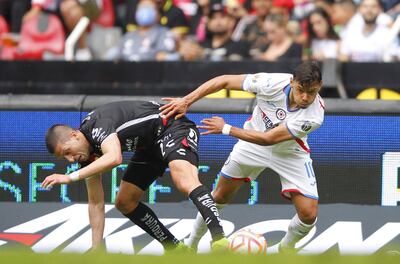 Martín Nervo (i) de Atlas disputa el balón con el paraguayo Ángel Romero (d) de Cruz Azul, durante el partido disputado ayer en el estadio Jalisco, en Guadalajara (México).