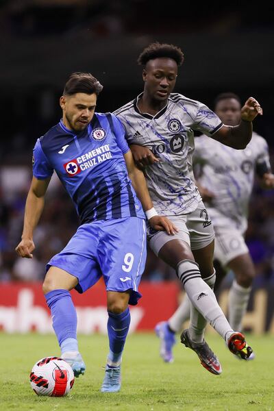 El paraguayo Ángel Romero (i) del Cruz Azul disputa el balón con Ismaël Koné del Montreal, durante el partido de ida por los cuartos de final de la Liga de Campeones de la Concacaf, en el Estadio Azteca de Ciudad de México .