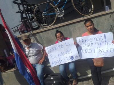 Inocencio Martínez, en compañía de sus hijas, encadenado frente al MOPC.
