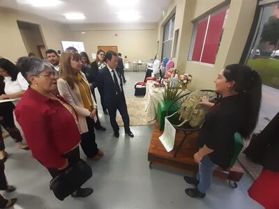 Una emprendedora muestra sus trabajos de indumentaria para personal militar a las autoridades.