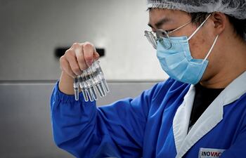 Un científico revisa las vacunas durante un tour a la nueva fábrica construida por para producir la vacuna contra el COVID-19 en Sinovac, una de las 11 compañías chinas que producirán vacunas de ese tipo.