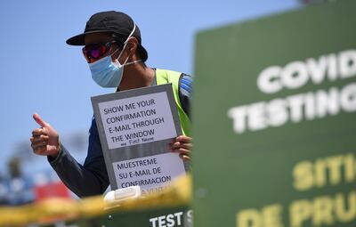 Un voluntario da indicaciones a automovilistas en un sitio de pruebas de COVID-19 en Los Ángeles, California.