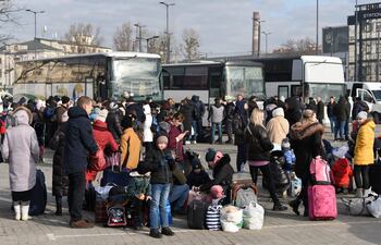 Parte de la población ucraniana huyendo hacia Polonia y a la espera de un autobus que los saque del país golpeado por la guerra con Rusia.