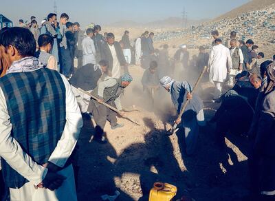 Personas asisten al entierro de las víctimas después de un atentado contra un bus en un área controlada por los talibanes.