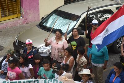 Mujeres portan palos al marchar sobre la calle Yegros de Asunción.