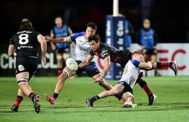 El yacaré Ramiro Amarilla taclea a su adversario ante la atenta mirada de Felipe Puertas.