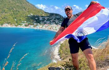 El mochilero compatriota Gerardo Franco con la tricolor en sus manos, en Cachacrou, Dominica.