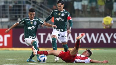 Un jugador del Independiente Petrolero queda tendido en el piso tras una acción con Gustavo Gómez y Eduard Atuesta, del Palmeiras.
