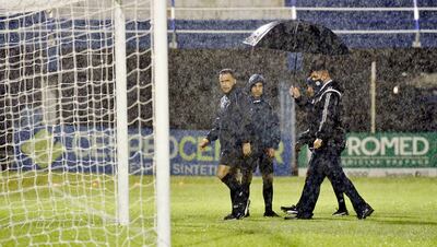 El árbitro Carlos Paul Benítez encabeza junto a sus colaboradores el recorrido por la mojada –y sin pintura– cancha del 12 de Octubre,