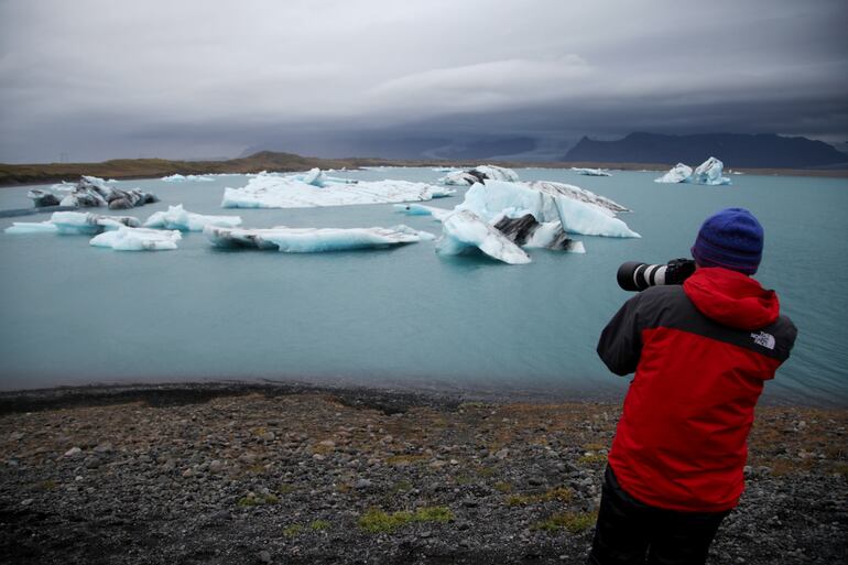 Un hombre fotografía la laguna glaciar Jökulsárlón, en el sur de Islandia. La cantidad de visitantes fue creciendo en forma constante en los últimos años, hasta llegar a un punto en que se buscaba estabilizarla para mantener un turismo sustentable. Pero el coronavirus revirtió completamente la tendencia.