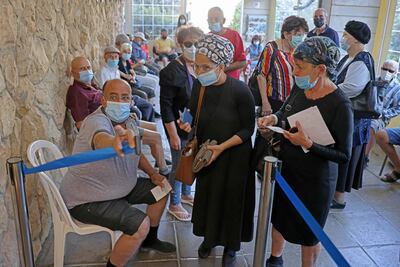 Los israelíes llegan para recibir su tercera dosis de la vacuna Pfizer en el Servicio de Salud Clalit en Jerusalén el 1 de agosto de 2021, cuando Israel lanzó su campaña para administrar inyecciones de refuerzo a personas mayores de 60 años.