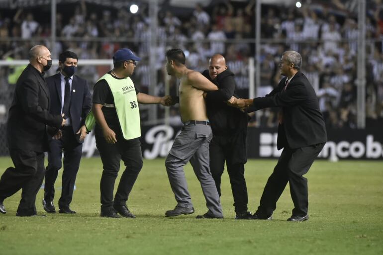 El hincha de Guaraní que ingresó al campo es sujetado y retirado por la seguridad privada de La Huerta.