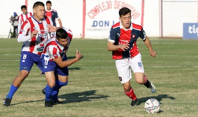 El “10” azulgrana Júnior Noguera se escapa de los Brítez, Carlos y Jorge “Mono” (6), capitán de Benjamín Aceval.