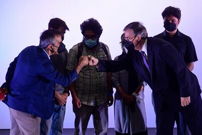 El periodista del New York Times, Michael Slackman (izq.), Y el canciller mexicano, Marcelo Ebrard (der.), chocan los puños durante una ceremonia de bienvenida para una representación de 124 corresponsales, reporteros y personal que trabajaron en varios medios en Kabul y solicitaron una ayuda humanitaria. visa de refugiado o asilo del gobierno mexicano.