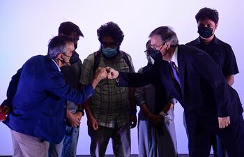 El periodista del New York Times, Michael Slackman (izq.), Y el canciller mexicano, Marcelo Ebrard (der.), chocan los puños durante una ceremonia de bienvenida para una representación de 124 corresponsales, reporteros y personal que trabajaron en varios medios en Kabul y solicitaron una ayuda humanitaria. visa de refugiado o asilo del gobierno mexicano.