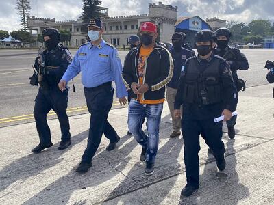 El presunto narcotraficante hondureño José Luis Oliva (c), conocido también como "El señor de los cielos", mientras es llevado por agentes a un avión de la DEA para ser extraditado a los Estados Unidos, hoy, en la base aérea Hernán Acosta Mejía, en Tegucigalpa (Honduras). El avión que lleva a Oliva, de la Agencia Antidrogas de los Estados Unidos (DEA), despegó a las 08.25 hora local (14.25 GMT) de la Base Aérea Hernán Acosta Mejía, en Tegucigalpa. Oliva, quien al parecer también tiene nacionalidad nicaragüense y usaba el nombre de Raduán Omar Zamora, fue solicitado en extradición el 6 de abril de 2021.