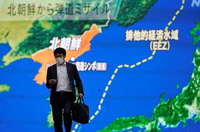 Un peatón en Tokio, Japón, camina junto a una gran pantalla de TV mientras se reporta el lanzamiento de misiles norcoreanos.