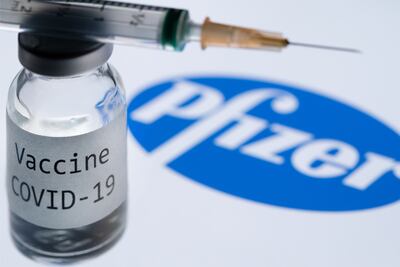 (FILES) In this file photo taken on November 23, 2020 This illustration picture taken in Paris on November 23, 2020 shows a syringe and a bottle reading "Covid-19 Vaccine" next to the Pfizer company logo. - Britain on December 2, 2020 became the first country to approve Pfizer-BioNTech's Covid-19 vaccine for general use and said it would be introduced next week. (Photo by JOEL SAGET / AFP)