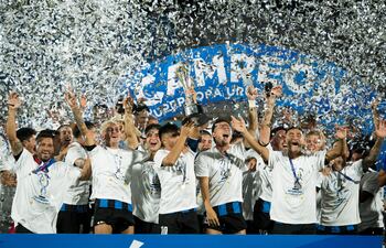 Miguel Samudio (primero de la izquierda) y sus compañeros del Liverpool festejan con la copa tras el partido final de la Supercopa 2022 de Uruguay entre Club Nacional y Liverpool Fútbol Club, el domingo, en el Estadio Centenario de la ciudad de Montevideo (Uruguay). El Liverpool uruguayo hizo méritos este domingo para quedarse con la Supercopa del fútbol local al derrotar 1-0 al Nacional en un encuentro en el que gran parte del tiempo los negriazules estuvieron con diez hombres en el terreno. EFE/ Enzo Santos
