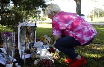 Doreen Folk, de Nueva York, deja un oso de peluch y flores en un improvisado memorial dedicado a Gabby Petito en North Port, Florida.
