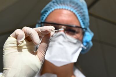 Un técnico exhibe una muestra nasal tomada a un paciente para analizar si tiene coronavirus, en el Centro Hospitalario Universitario, en Francia.