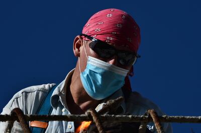Un obrero con mascarilla trabaja en la construcción de un puente en Tegucigalpa, Honduras.