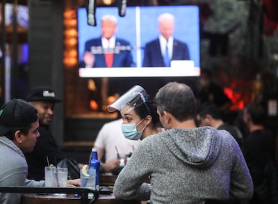 Varias personas miran el debate entre Donald Trump y Joe Biden en un restaurante en Hollywood, California, el pasado jueves.