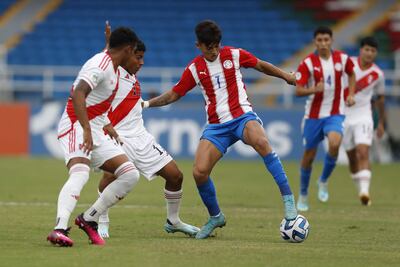Diego González (d) de Paraguay disputa un balón con Diether Vásquez (c) de Perú en el partido de la fase de grupos del Campeonato Sudamericano Sub'20 entre las selecciones de Paraguay y Perú en el estadio Pascual Guerrero en Cali (Colombia).