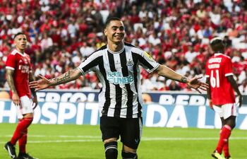 Miguel Almirón celebra uno de sus goles en medio de dos jugadores del Benfica.