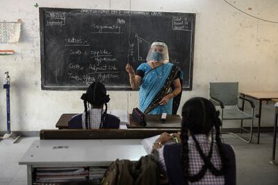 Una maestra imparte clases en una escuela secundaria de niñas del gobierno en medio de la pandemia de coronavirus, en Hyderabad, India.