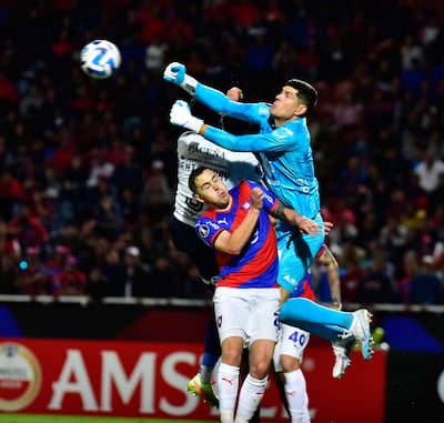 El arquero del Bolívar, Carlos Lampe sale a despejar el balón con los puños ante la arremetida del azulgrana Robert Piris Da Motta. El defensor del Ciclón tuvo una jornada complicada con su tanto en contra.