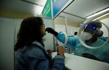 Personal médico privado realiza pruebas de hisopados para detectar COVID-19 a los pasajeros que llegan al aeropuerto internacional de Tocumen, cerca de la Ciudad de Panamá (Panamá).