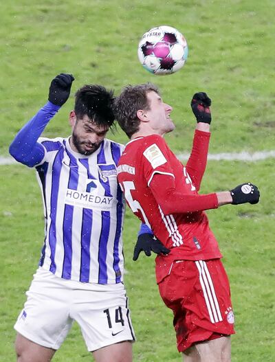 Duelo aéreo por el balón entre el zaguero paraguayo Omar Alderete, del Hertha, y Thomas Müller, del Bayern, (AFP).